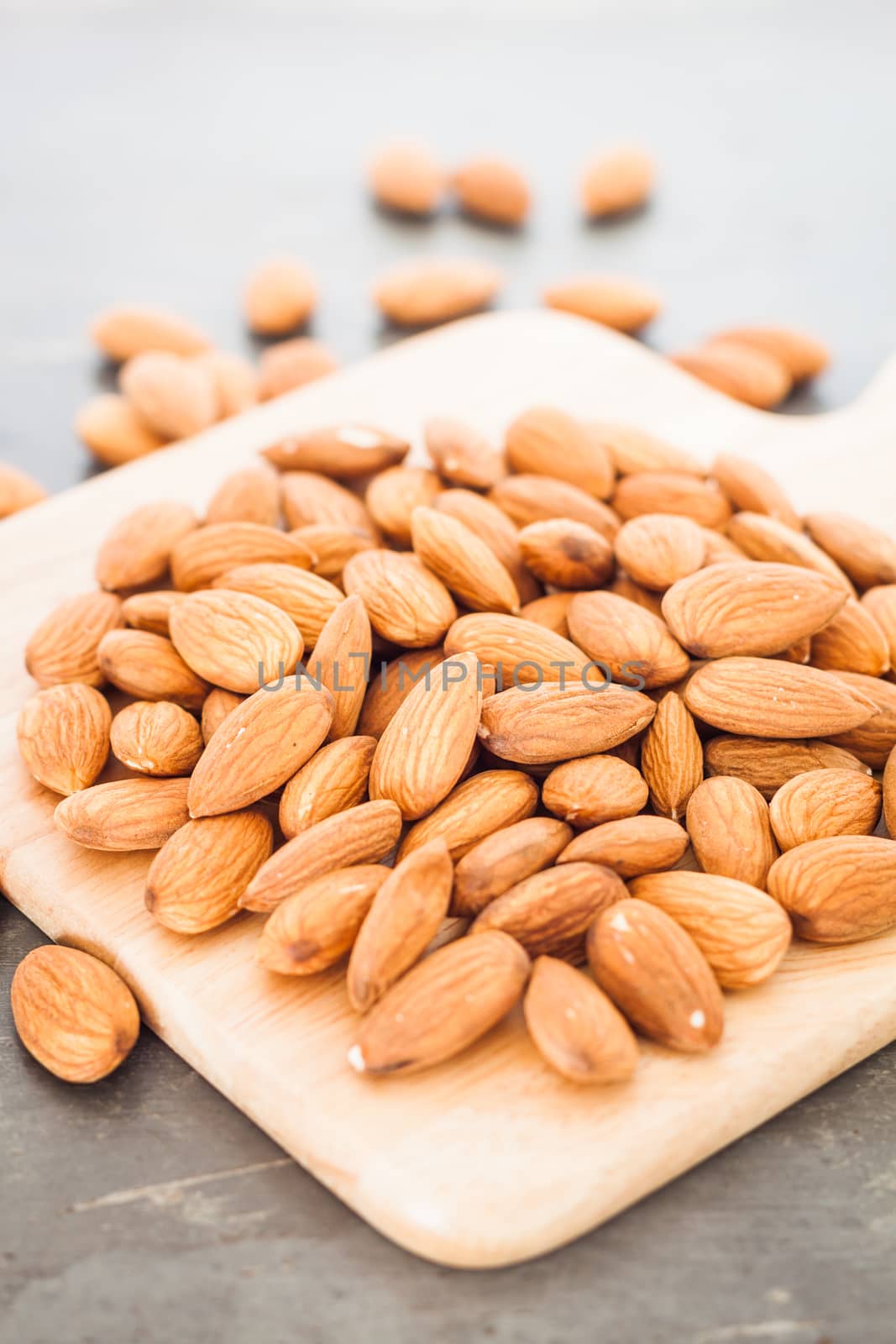 Almond nuts on wooden plate, stock photo