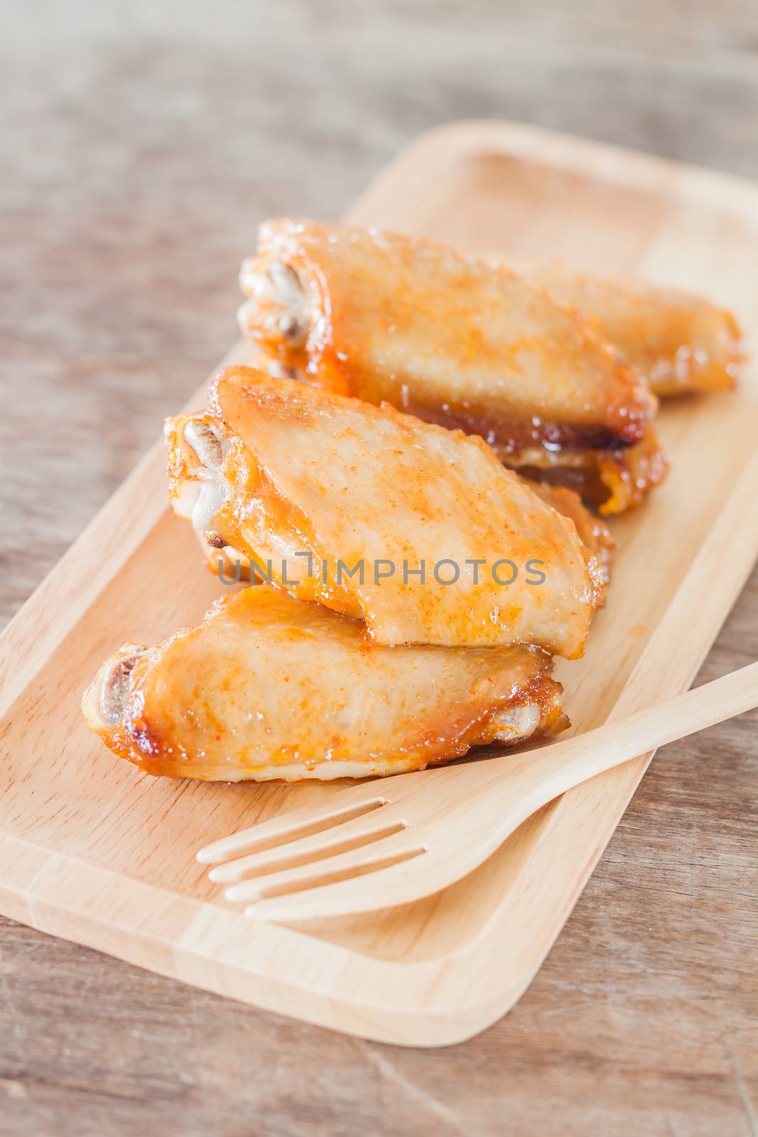 Grilled chicken wings on wooden plate, stock photo