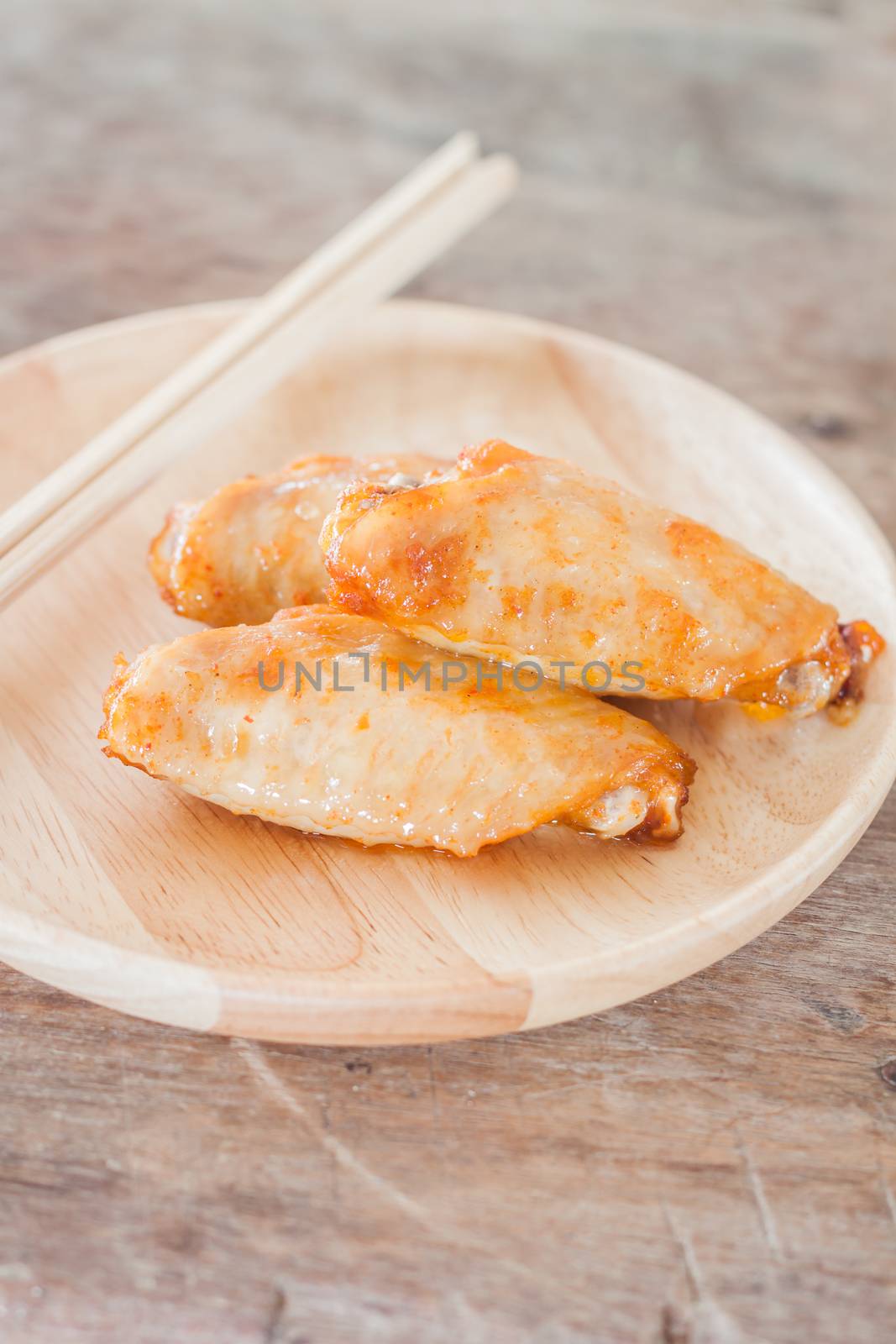 Grilled chicken wings on wooden plate, stock photo