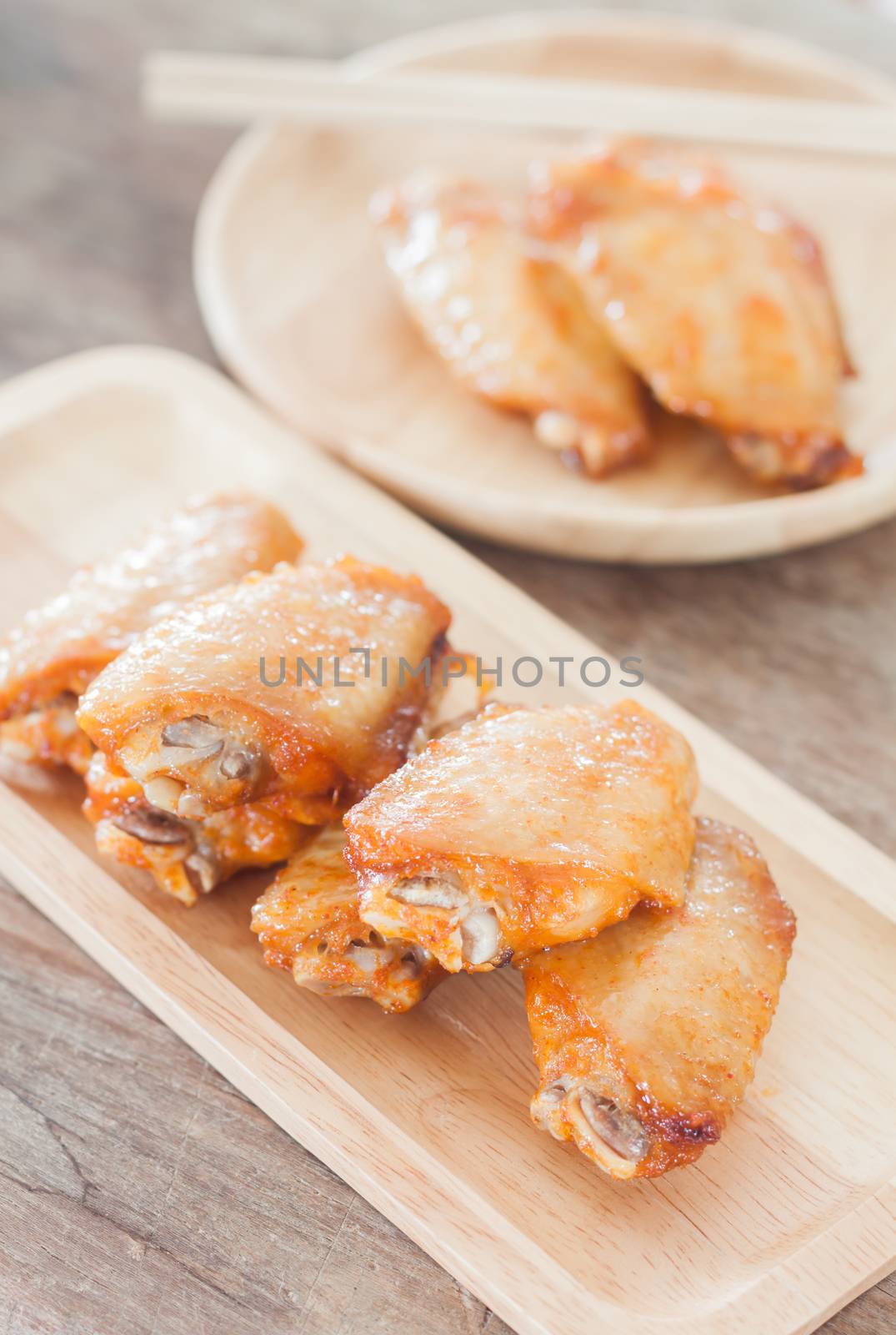 Grilled chicken wings on wooden plate by punsayaporn