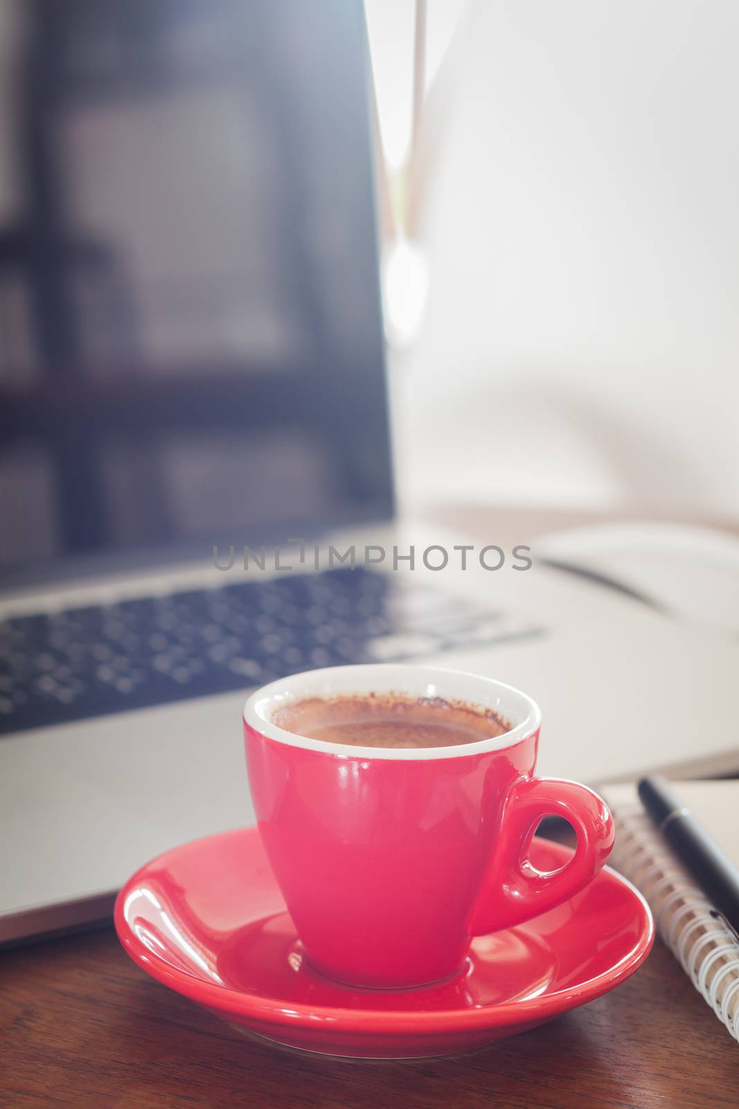 Red coffee cup with notepad and laptop, stock photo