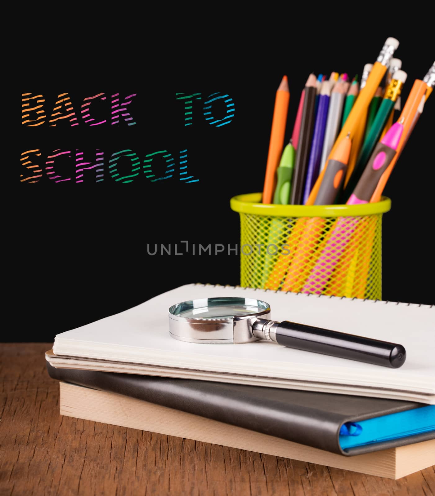 notebook and a container of pencils on the table