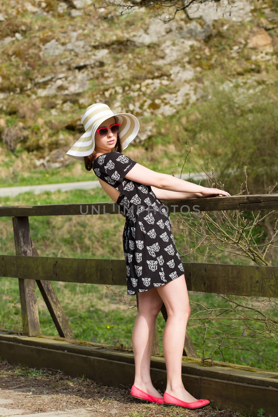 Cheerful fashionable woman in stylish hat, frock and sunglasses Happy brunette girl with long hair in warm spring day