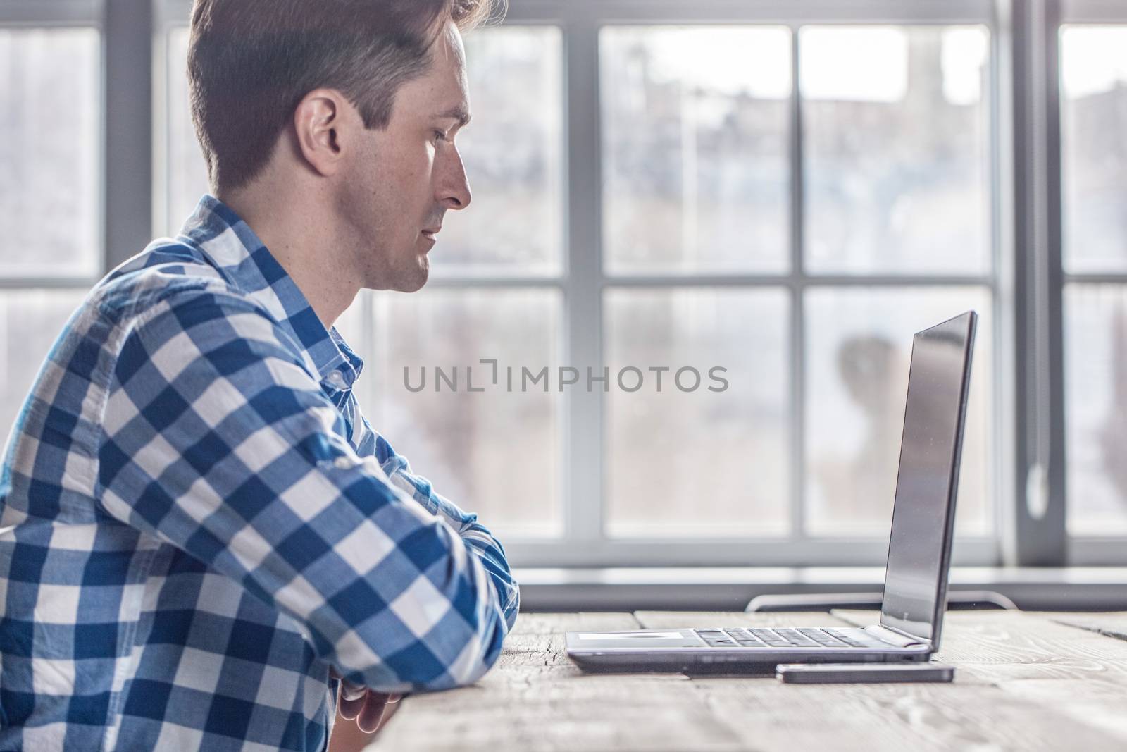 Man in casual clothes using a laptop computer in office