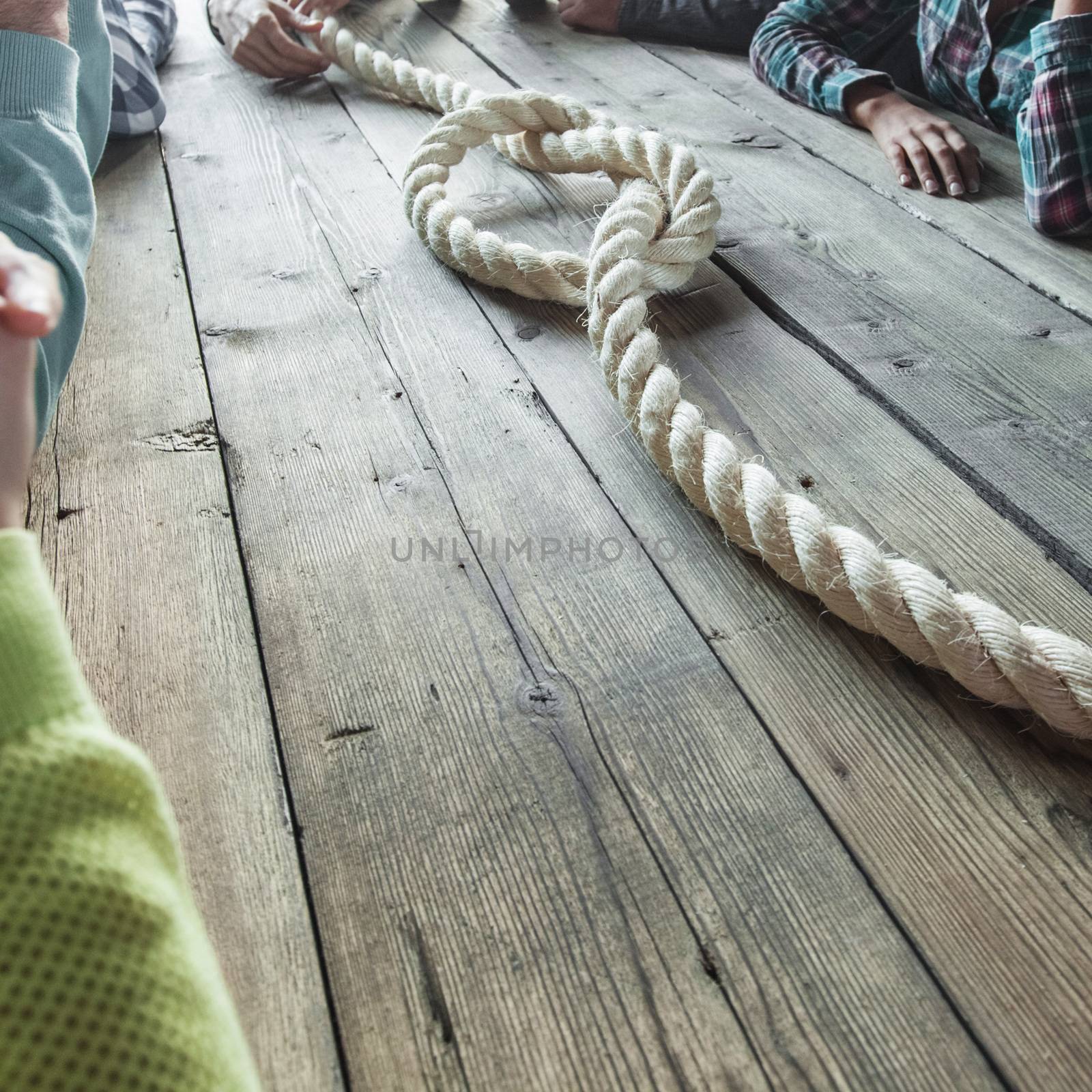 People sitting around the table with rope node on it, business problem concept