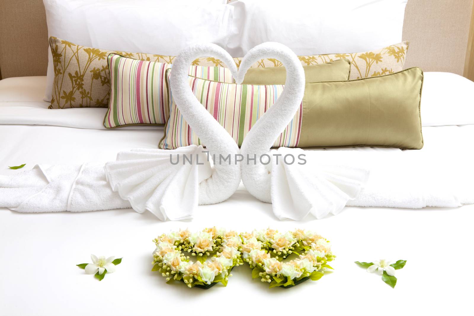 White pillows and gold pillws on bed and swan on bed.