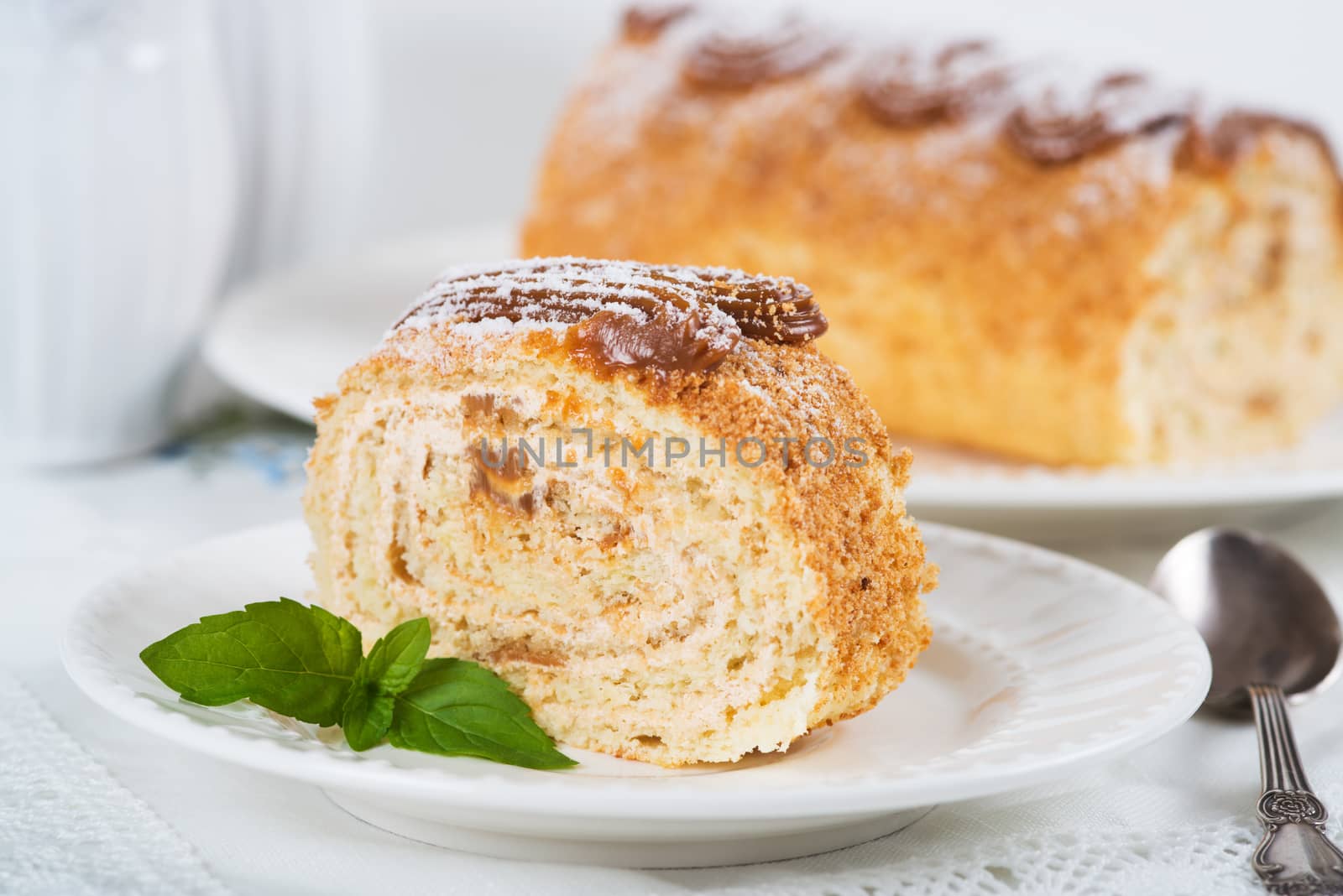 Biscuit roll with condensed milk on a table, selective focus