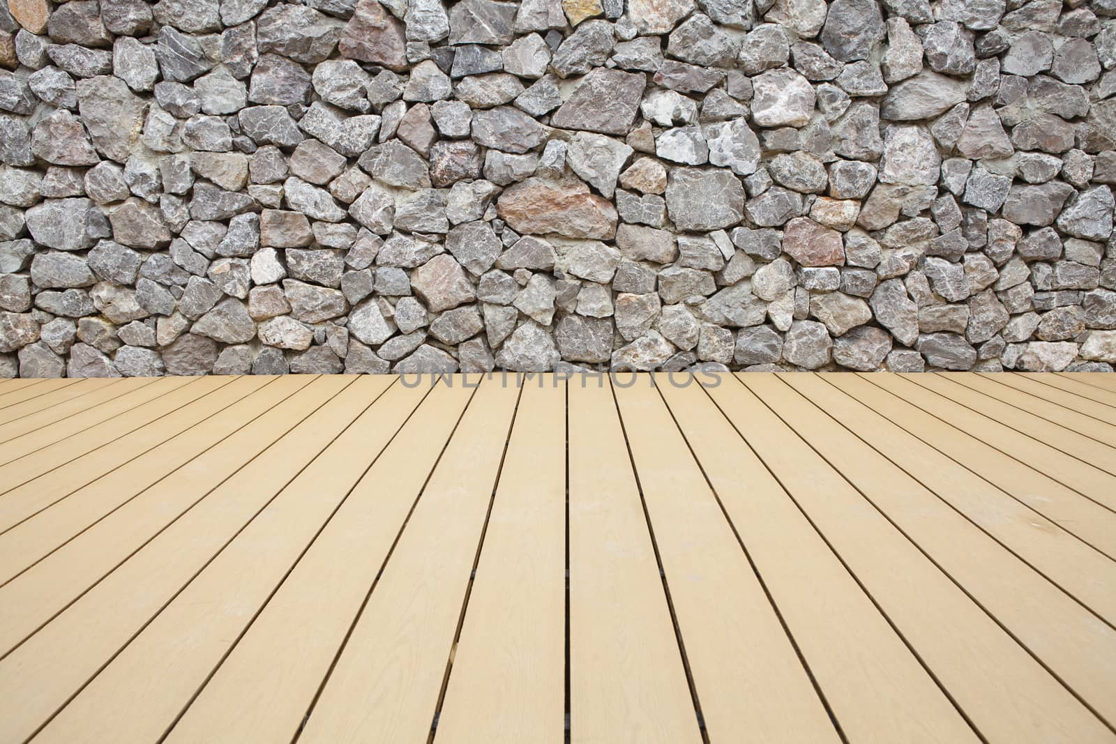 Wood floor boards with a stone wall background
