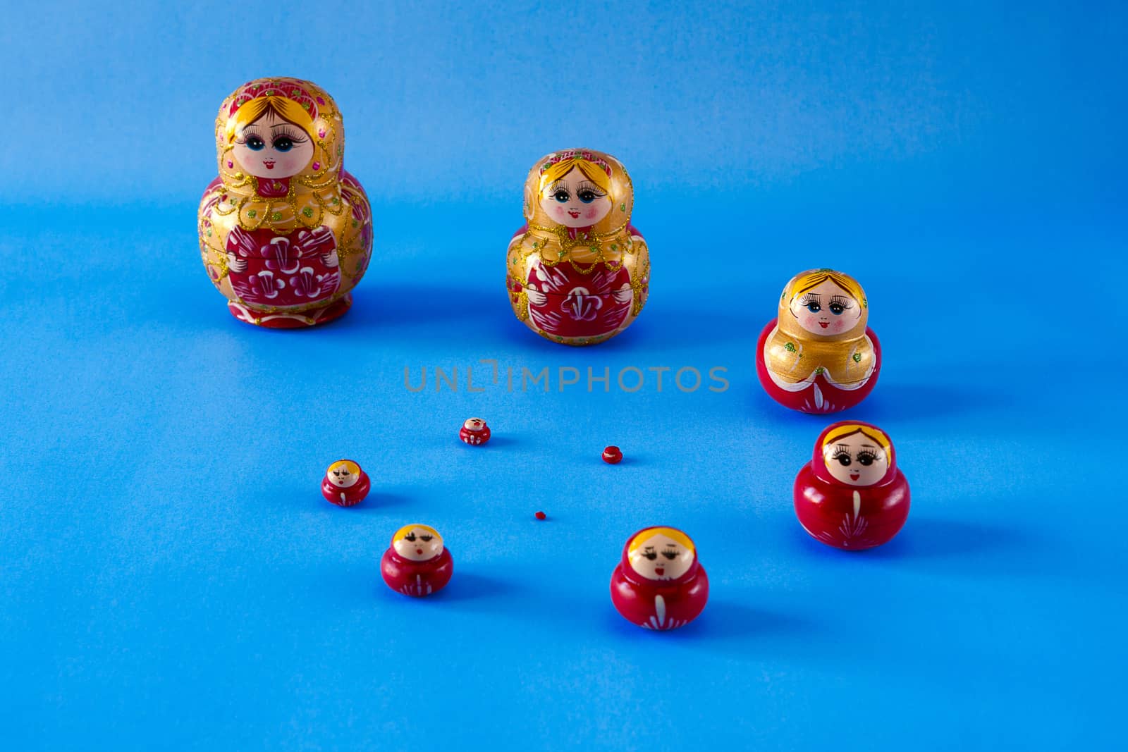 A family of matrioska in spiral on blue background