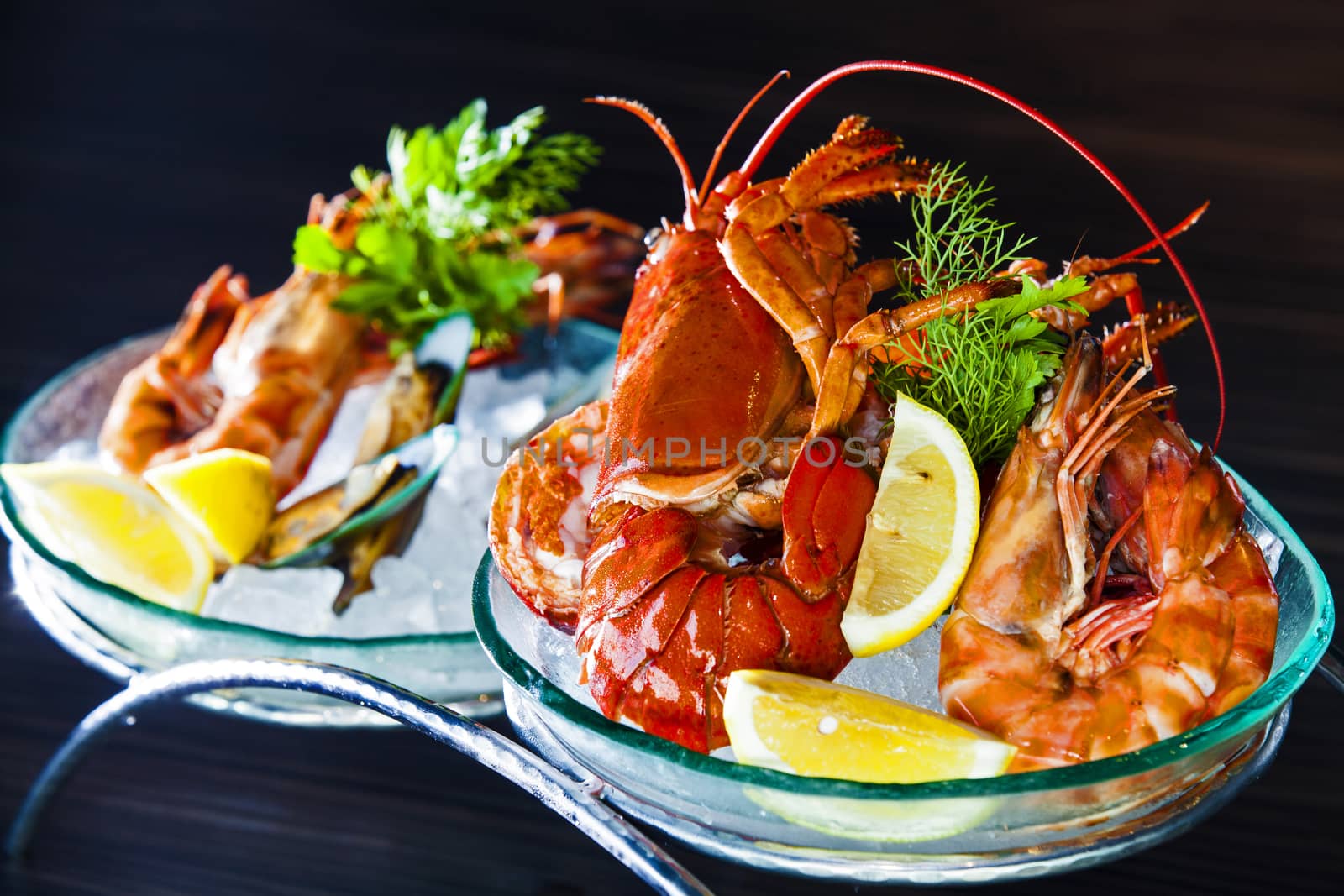 Chilled large shrimps on crushed ice with dill and lemon, selective focus.