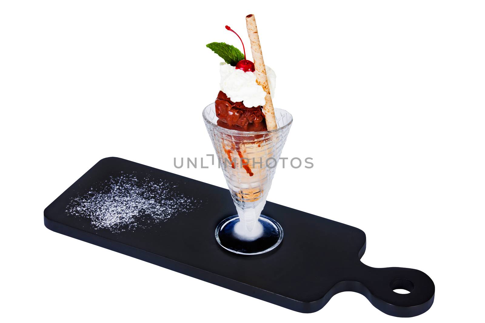 Ice cream with fruit and grated chocolate in a glass on a dark background.