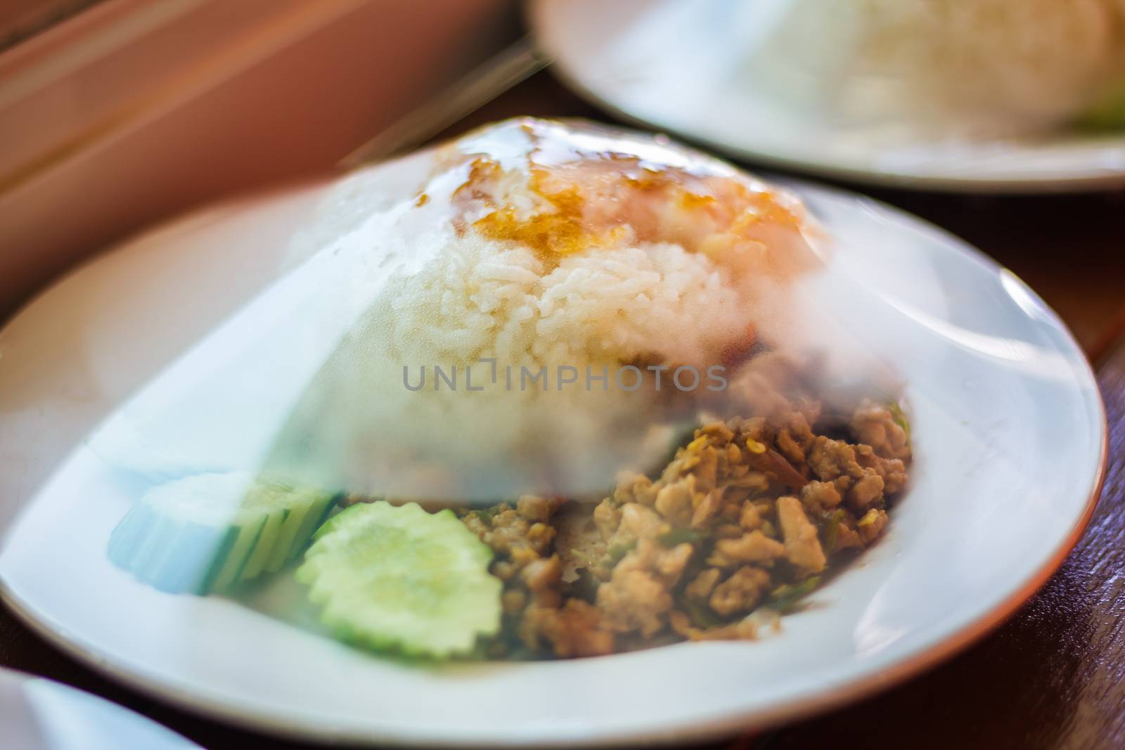 Rice topped with stir-fried chicken, basil and fried egg, fried stir basil with minced chicken on white background