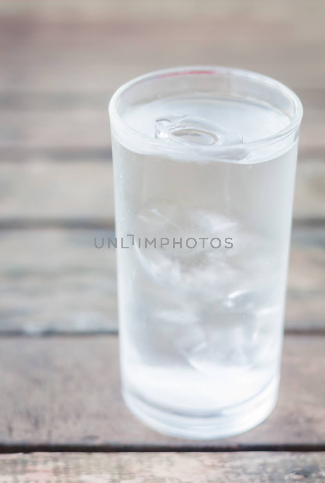 Glass of iced water on wooden table, stock photo
