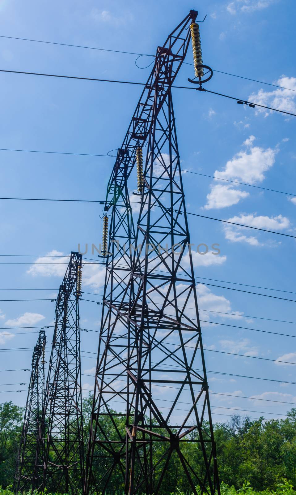 v supports of high-voltage power lines against the blue sky