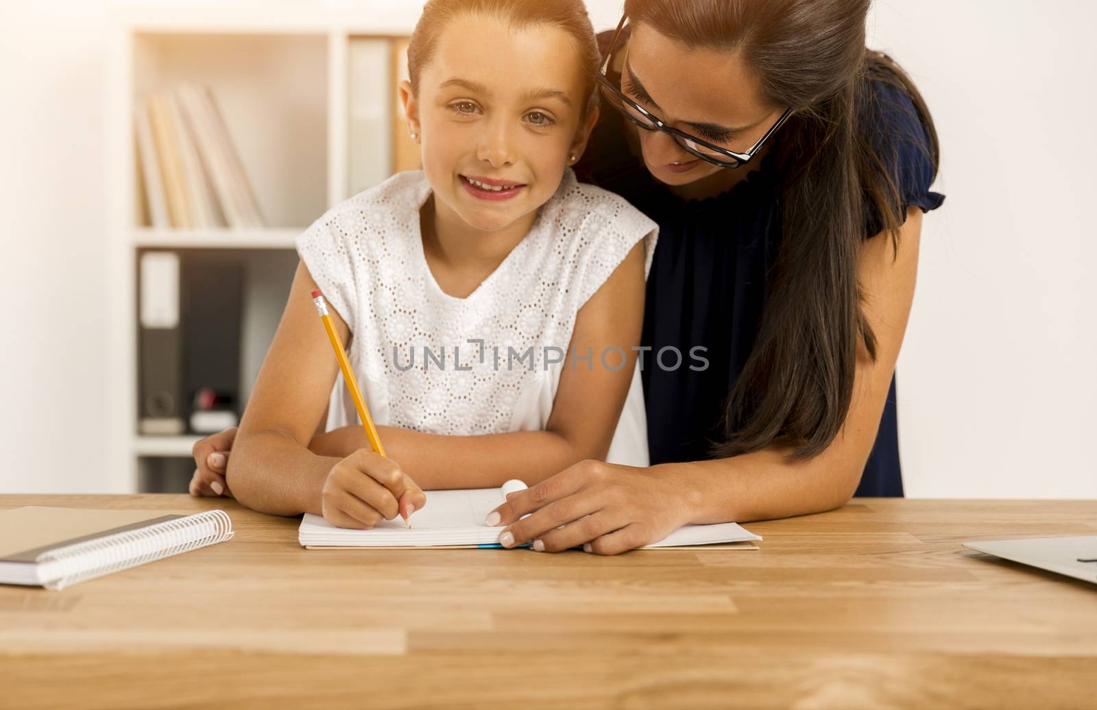 Mother and daugther at home doing homework together