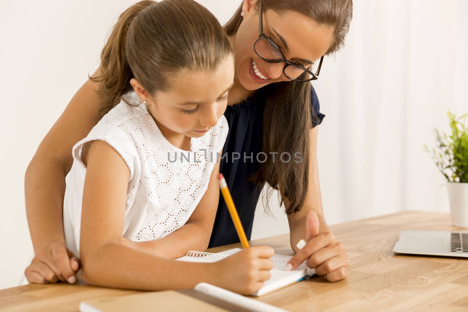 Mother and daugther at home doing homework together