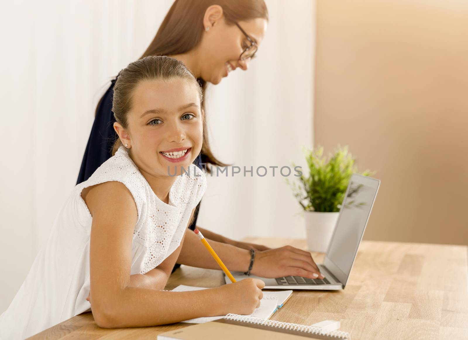 Mother and daugther at home doing homework together