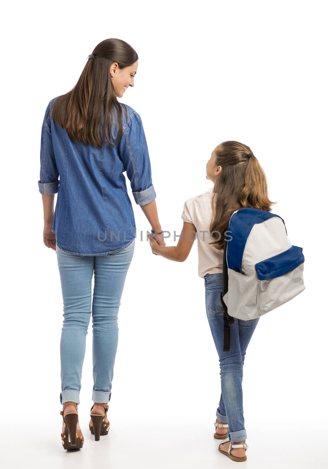 Mother and her little daughter walking together going to the school