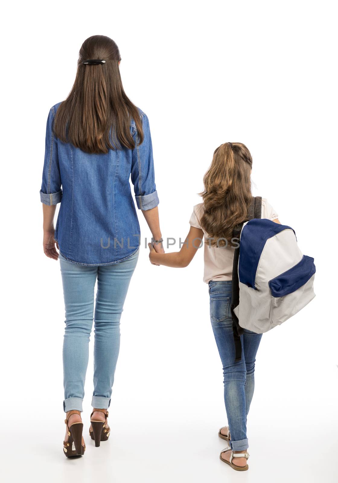 Mother and her little daughter walking together going to the school