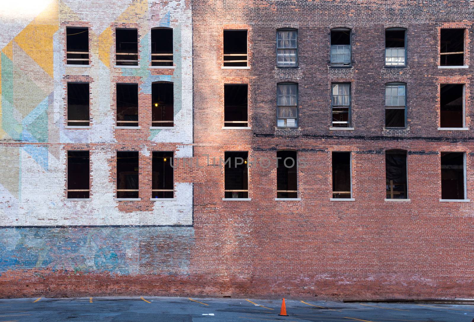 Old abandoned building in the downtown of Detroit. Facade made of bricks, partly with a colorful painting. Broken windows.