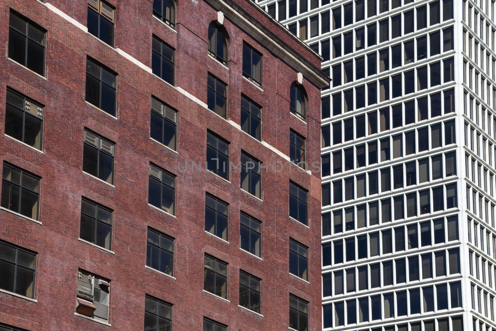 Side by side, old abandoned bricks building and modern white skyscraper. Detroit, Michigan, United States of America