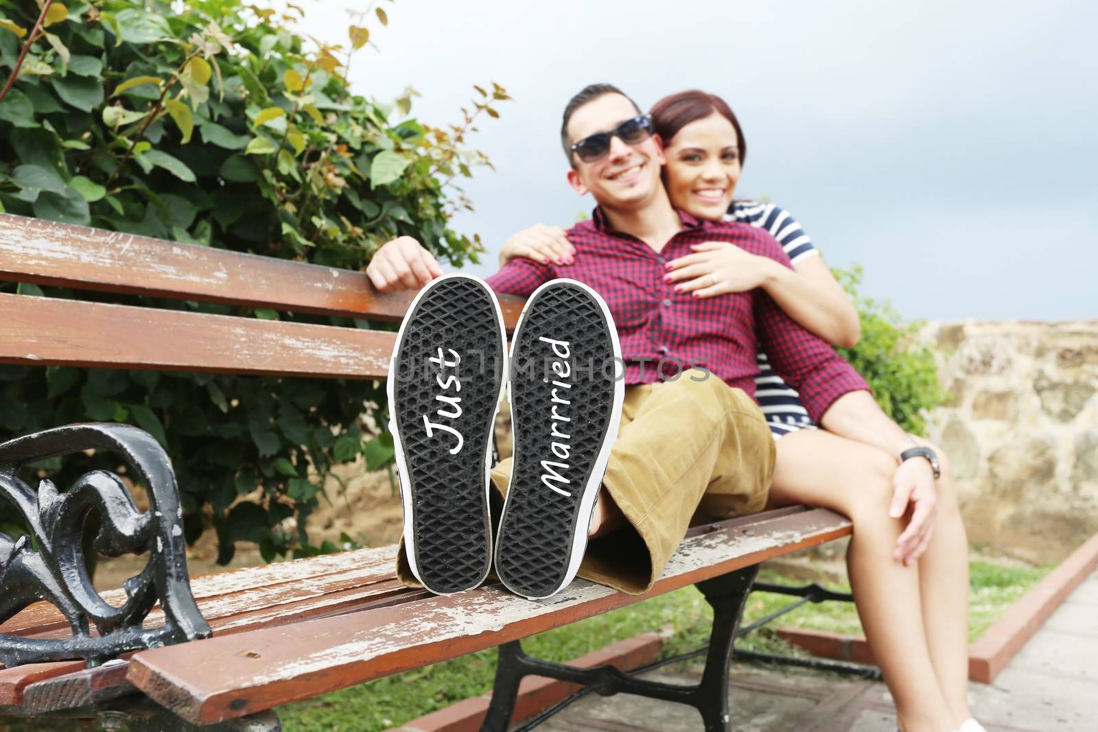 Young beautiful couple with message "Just married" in his shoes. Focus in the shoes.
