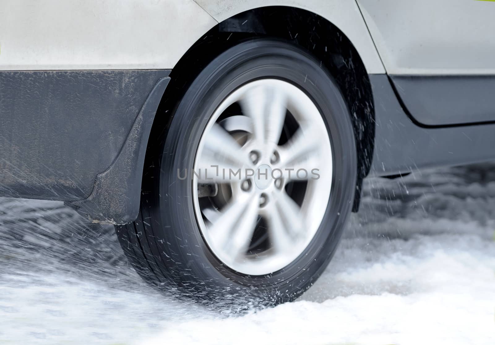 Dirty car wheel stands on winter snowy road