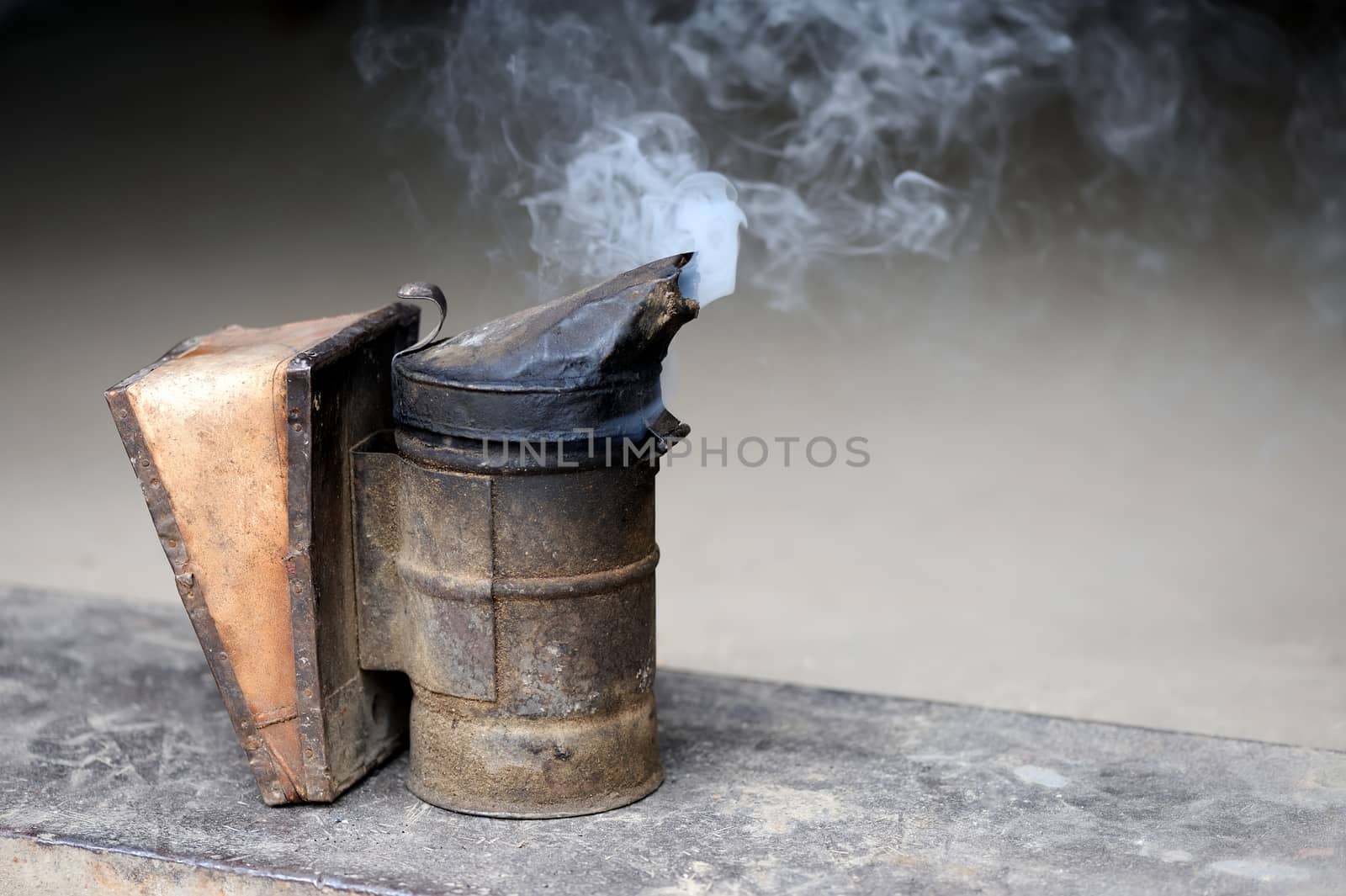 Closeup of bee smoker on crate at farm