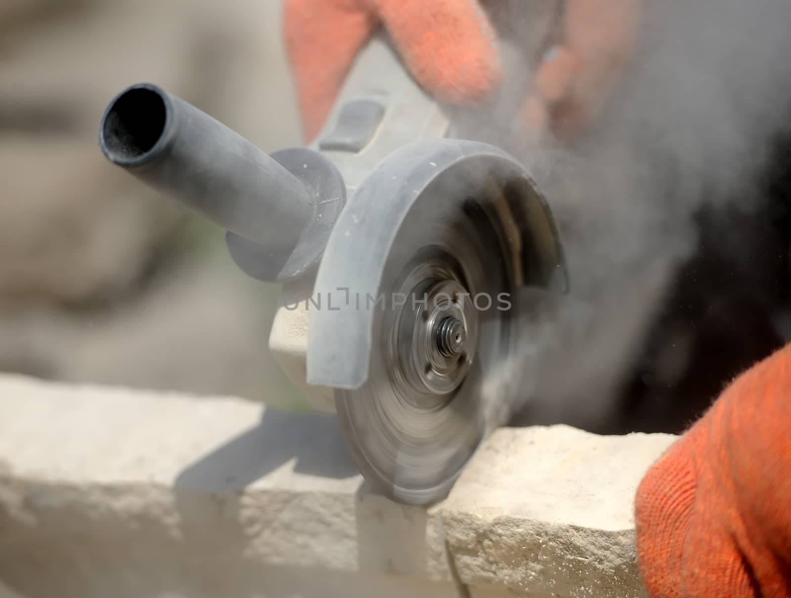 Grinder worker cuts a stone the electric tool