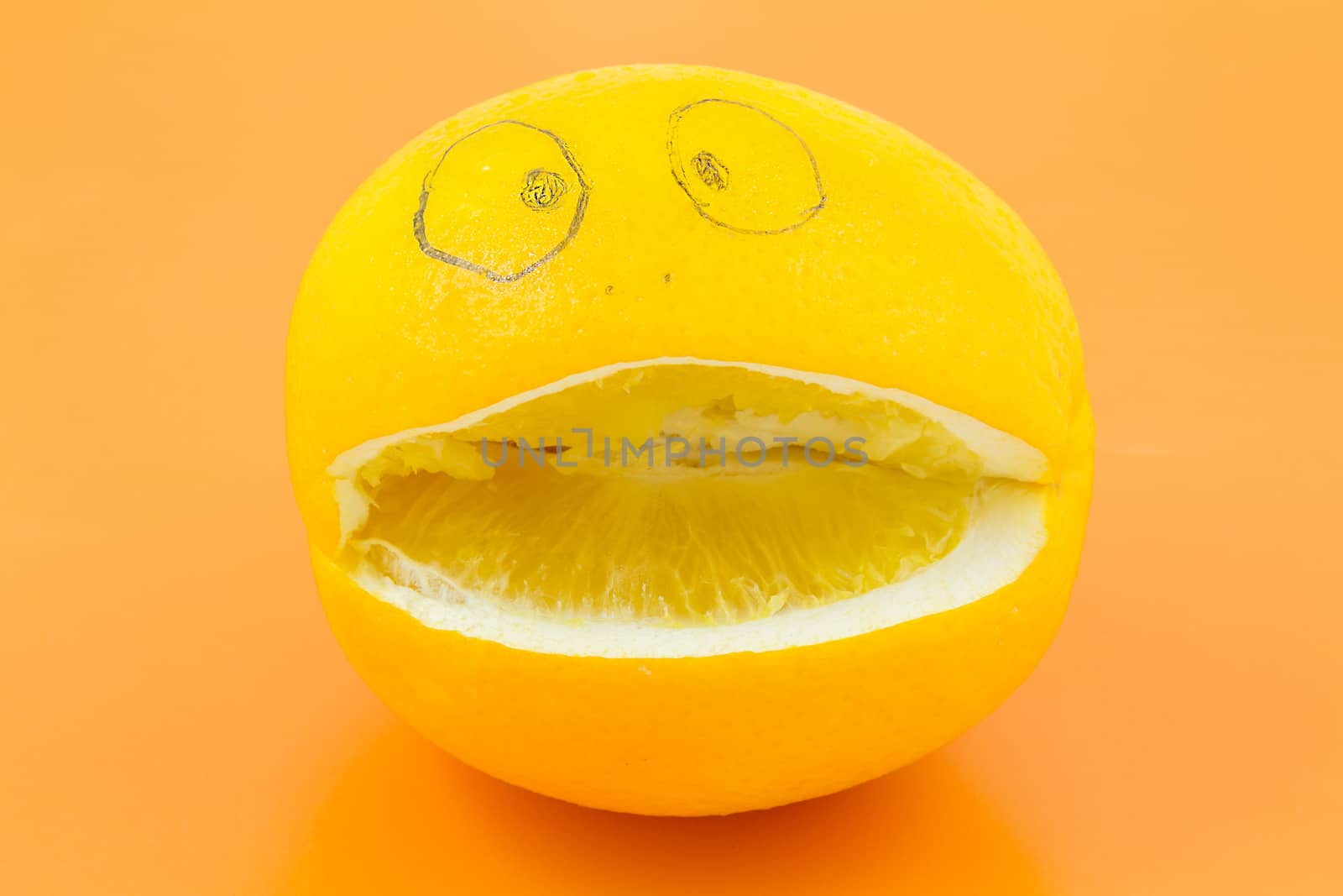 Funny orange with eyes, nose and mouth on an orange background.