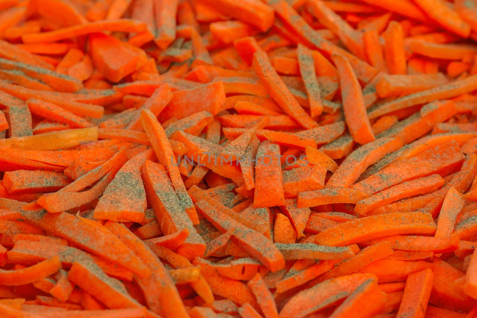 Closeup of chopped carrots with pepper in a large bowl