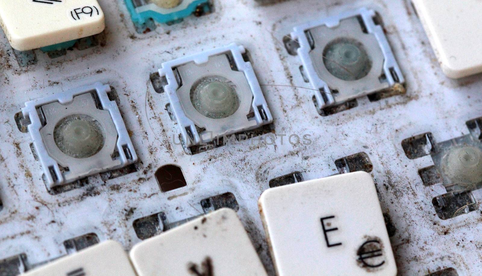 A close view of some keys on a dirty, yellowed keyboard. by nehru
