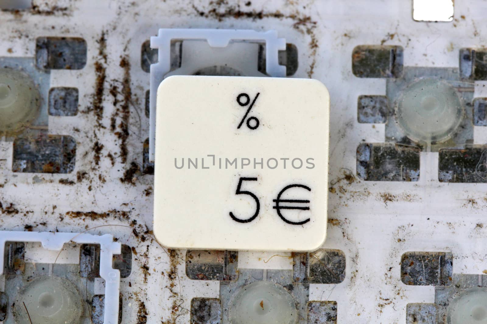 A close view of some keys on a dirty, yellowed keyboard. number 5 and euro sign