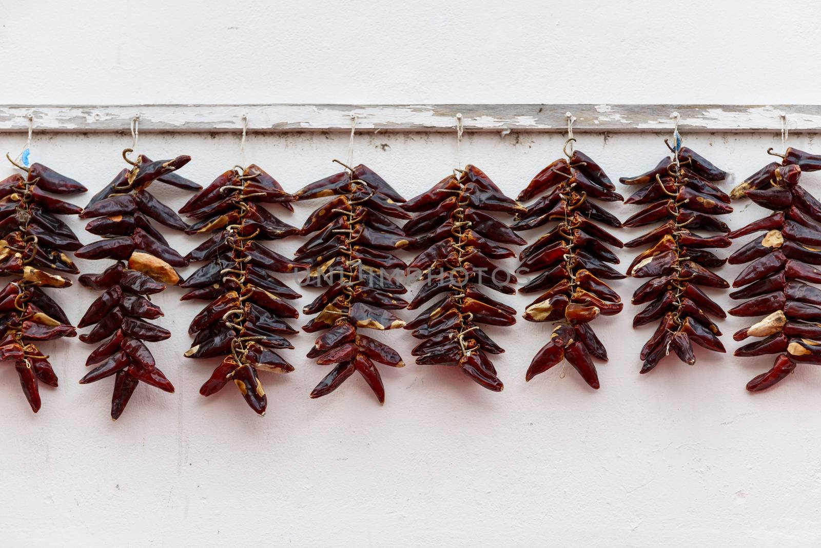 Strings of PDO Espelette chilli peppers drying, France