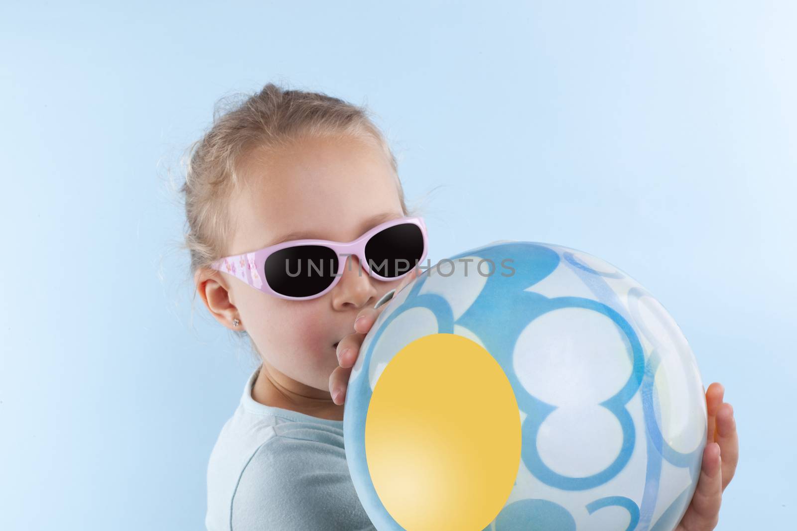 Summer. Beautiful small girl with ball and sunglasses. by eskymaks