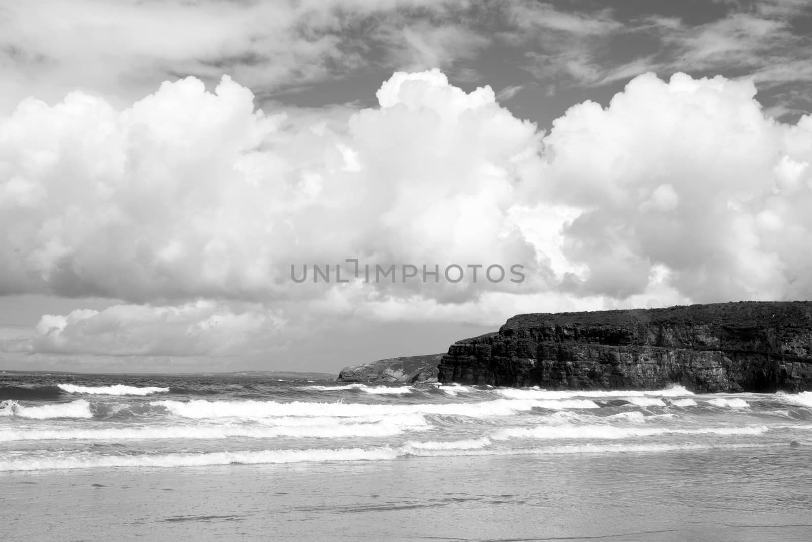 lone surfer on waves at the cliffs and beach in ballybunion on the wild atlantic way