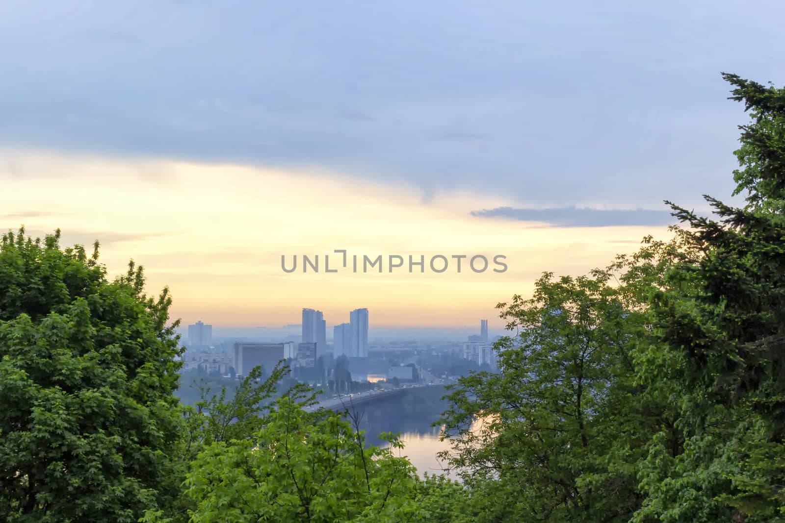Sunrise in Kiev Botanical Garden overlooking the left bank of the Dnieper river reflecting in water