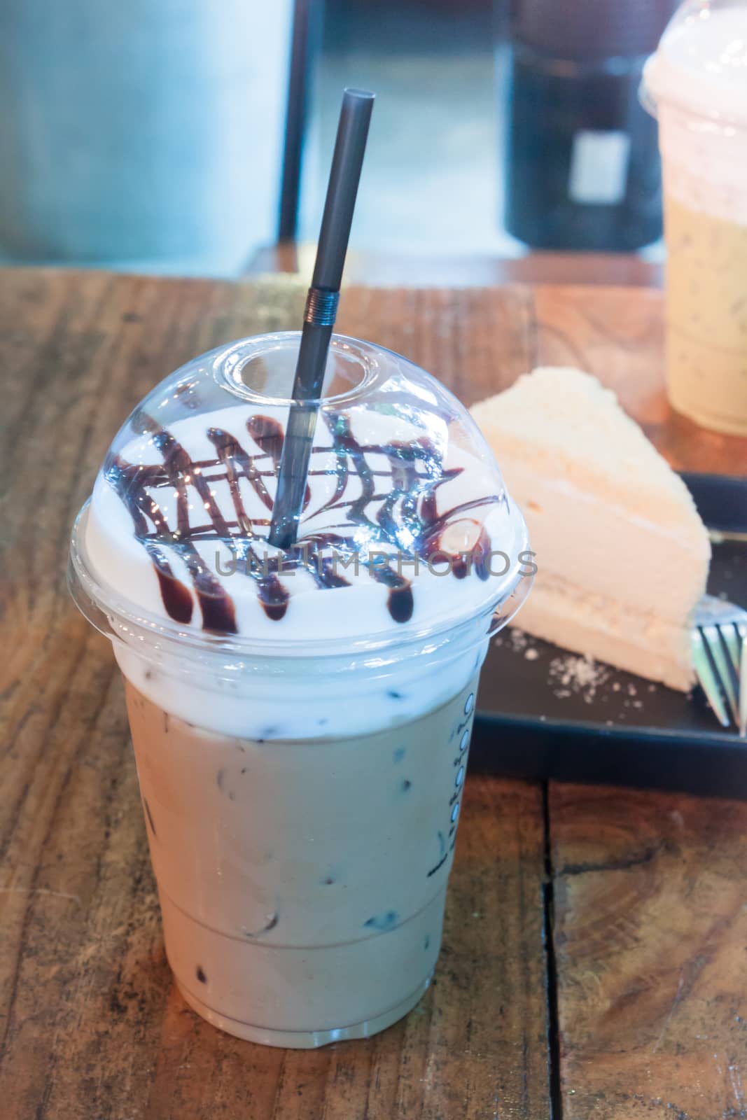 Take-home ice coffee cup on wooden table by punsayaporn