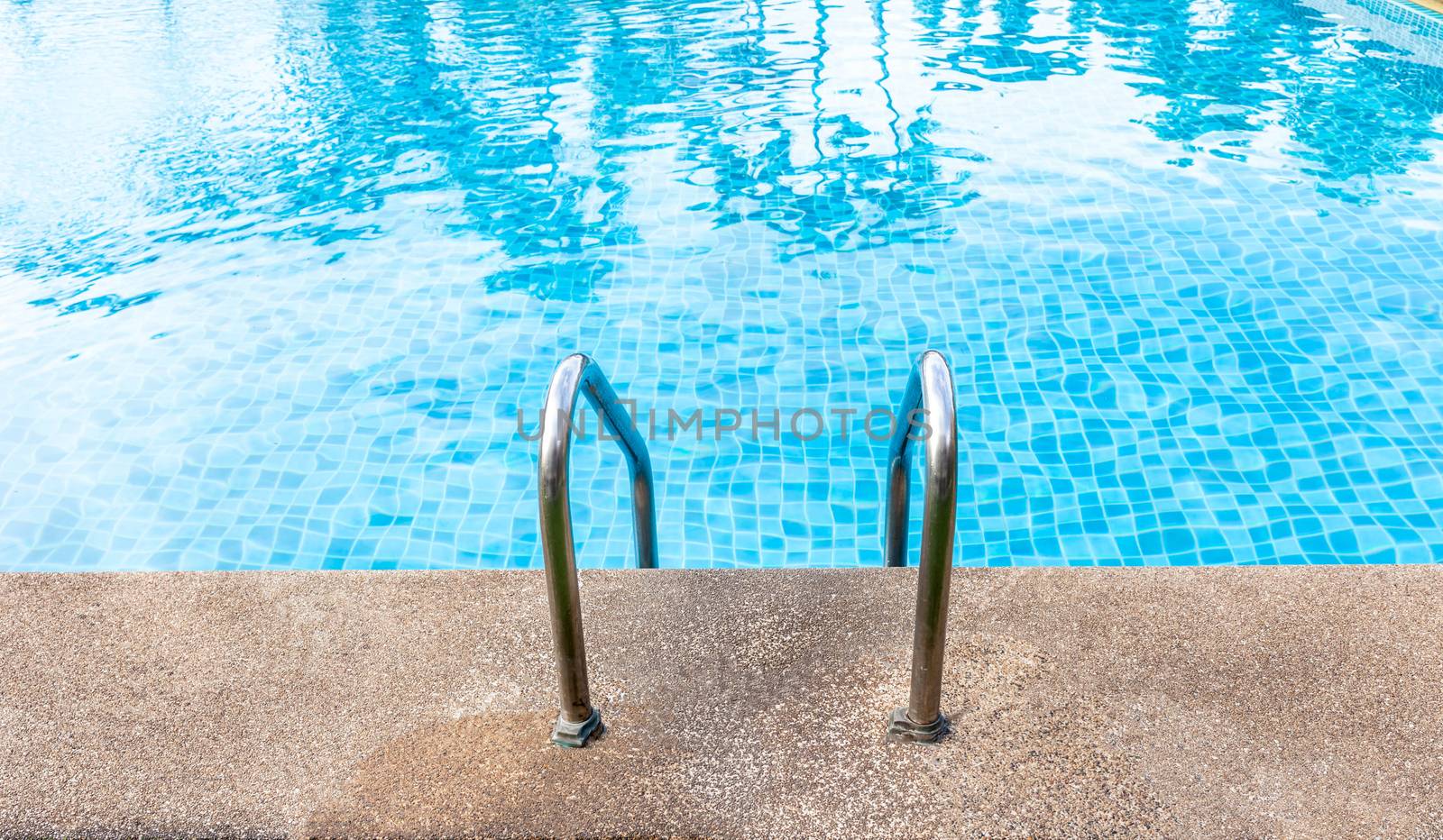 Staircase into the swimming pool with blue tiled. View from eye by nopparats