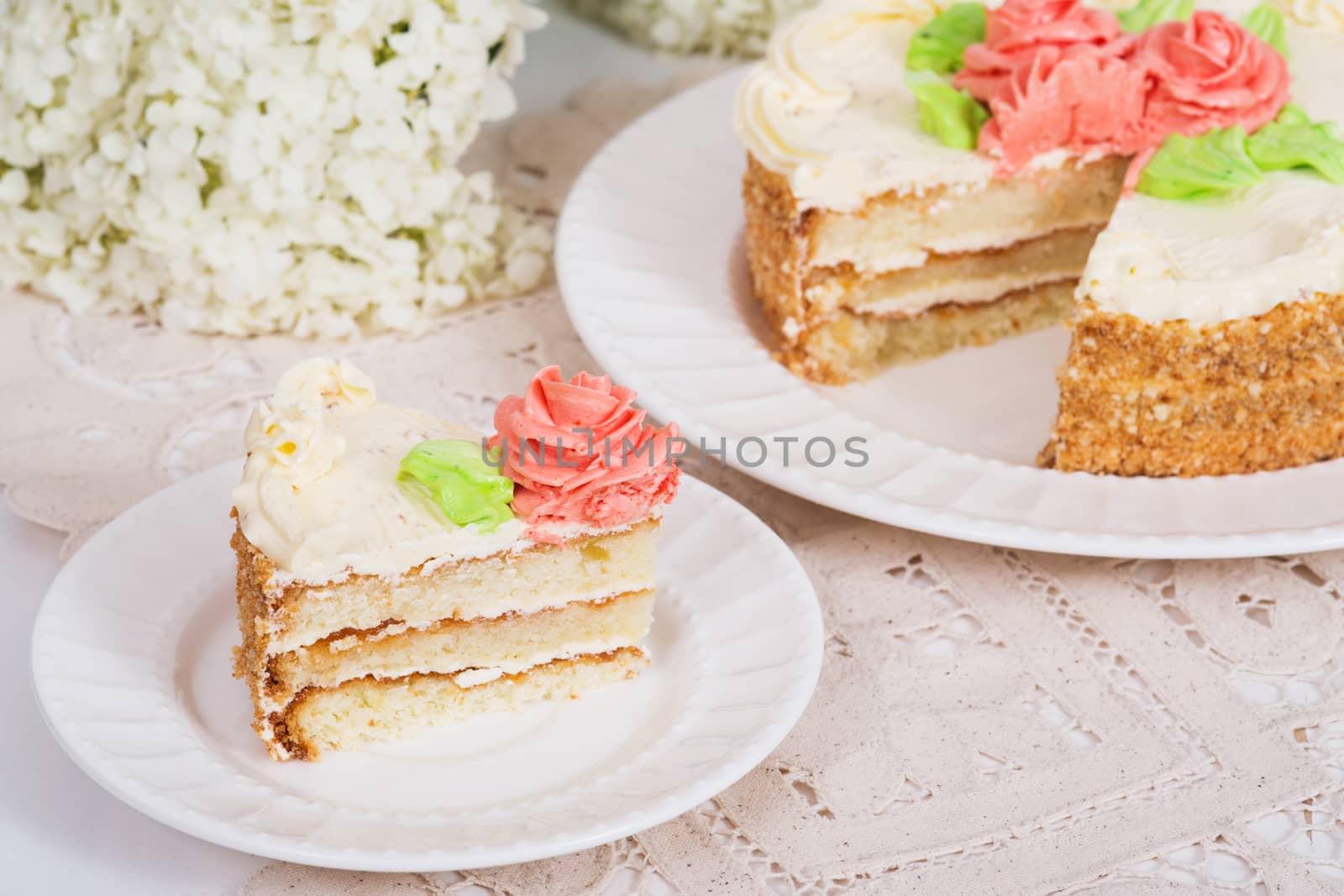 Creamy cake on plate on table on light background, selective focus.