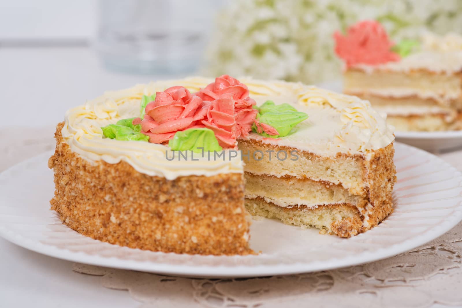 Creamy cake on plate on table on light background, selective focus.