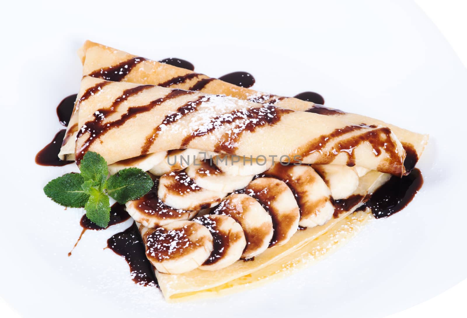 Pancakes stuffed bananas and chocolate on a plate, isolated