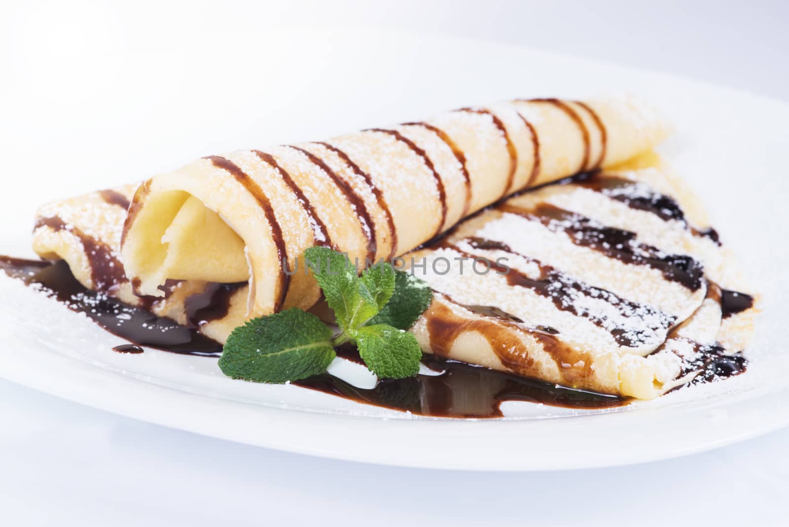 Pancakes with chocolate sauce and mint  on a plate