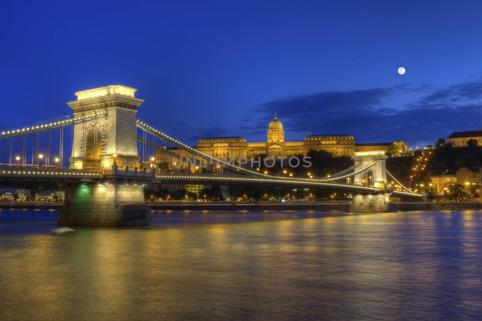 Chain Bridge, Royal Palace and Danube river in Budapest by night with full moon, Hungary, HDR