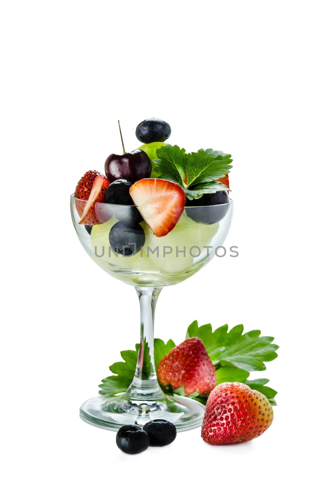 Fresh forest berries and melon  in a glass on a white background isolated