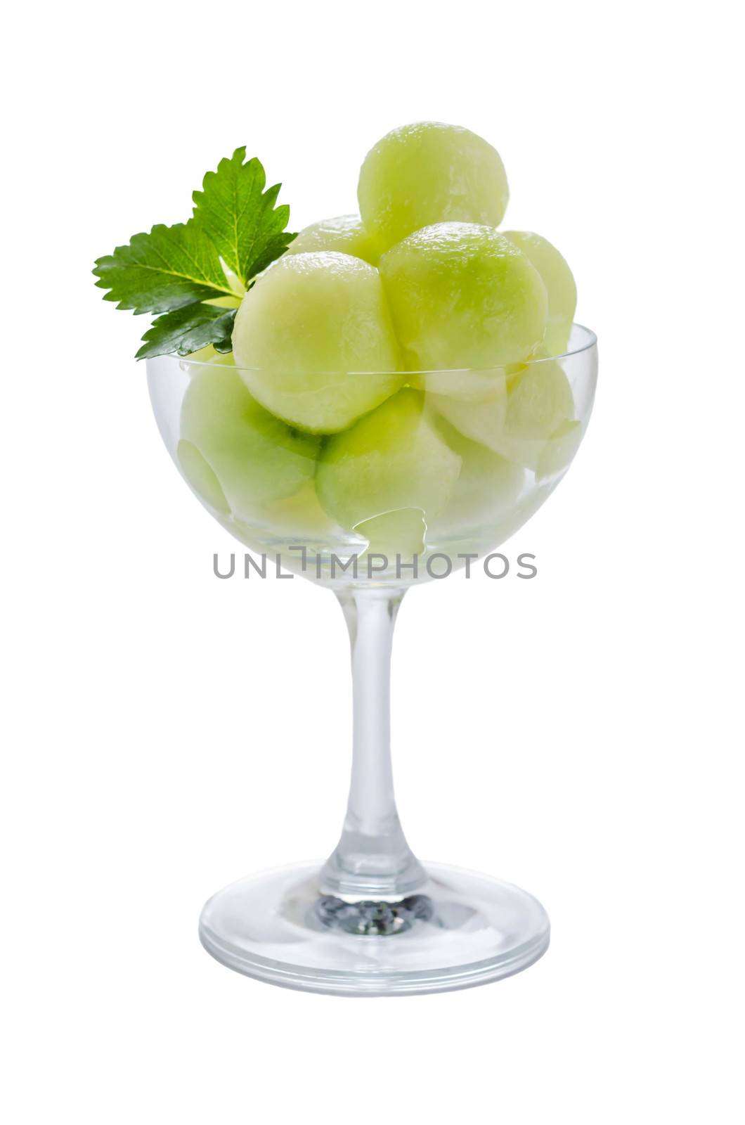 Fresh green cantaloupe melon in glass on a white background