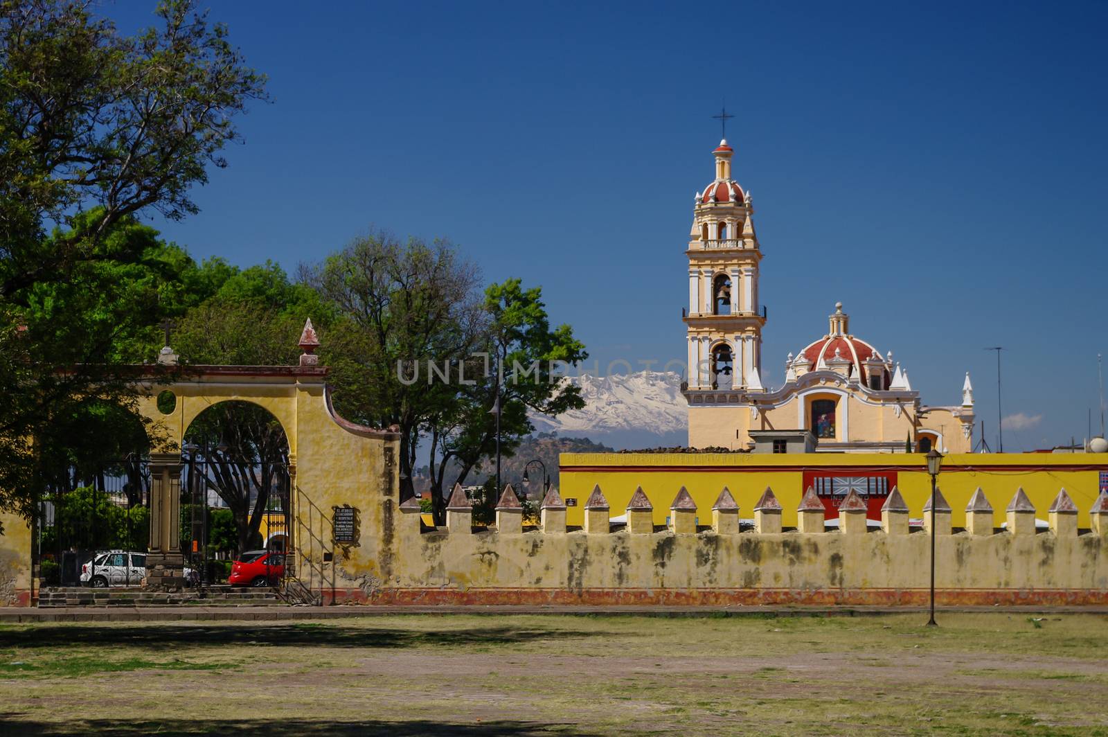 View of the church with yellow fence on the background of the volcano, Mexico