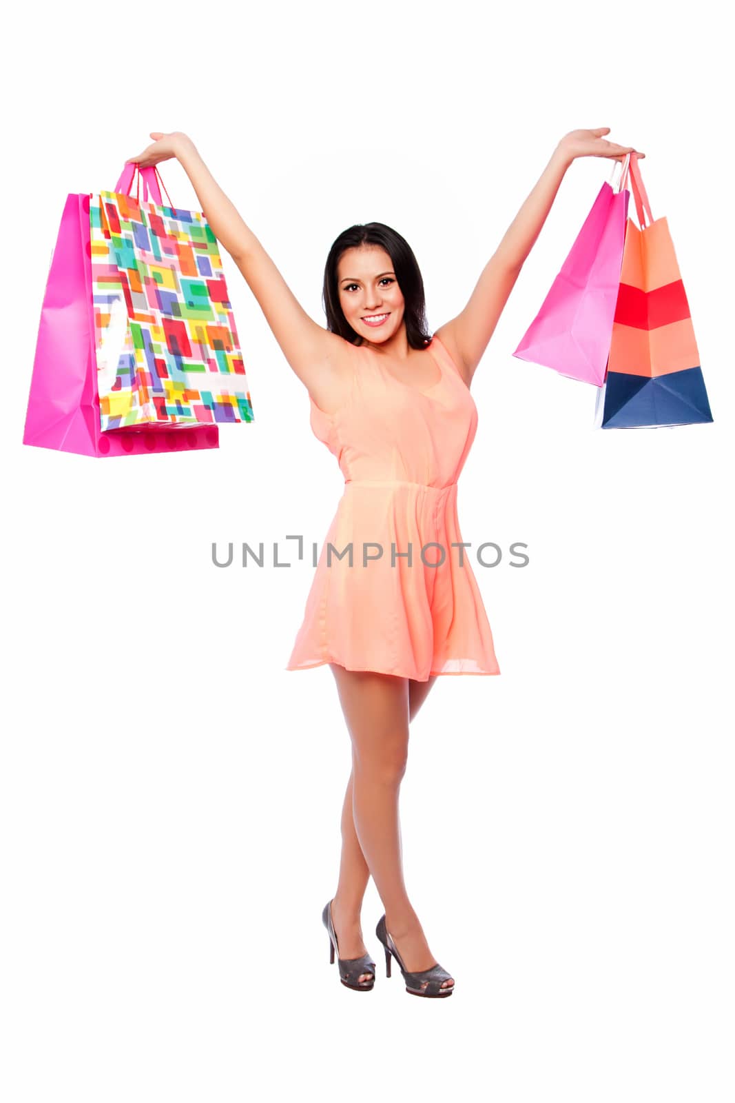 Beautiful happy woman with shopping bags on shoppingspree standing cute with arms in air, consumer lifestyle concept.