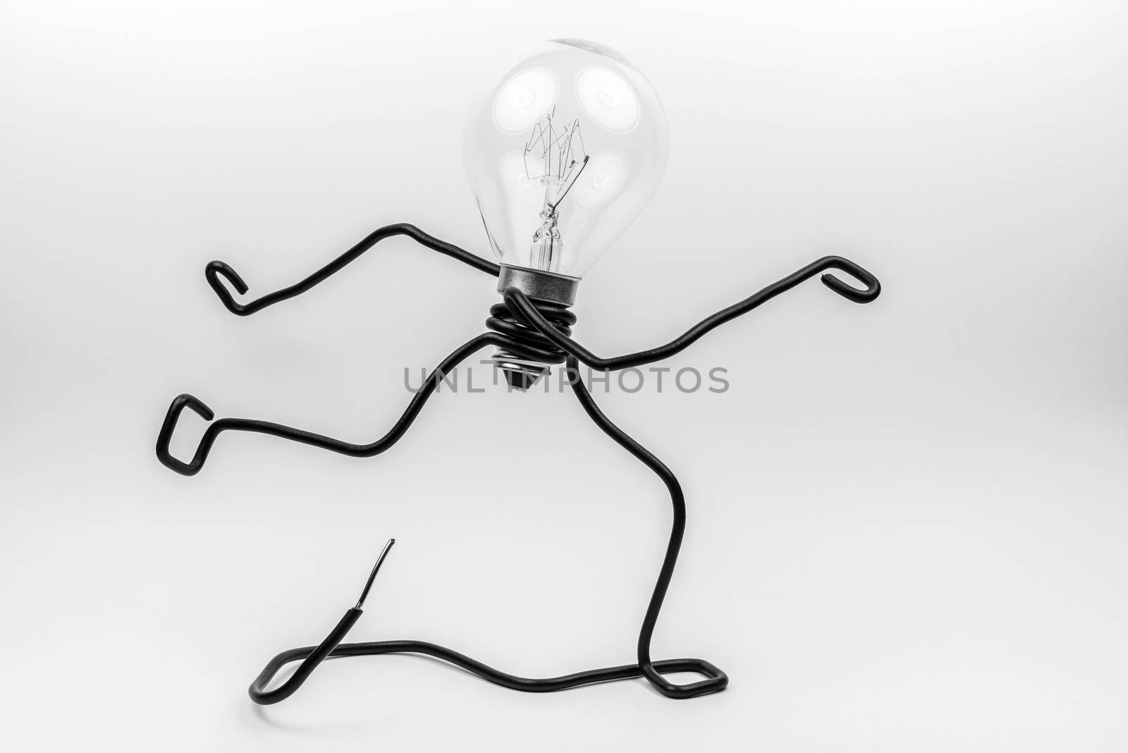 Emotional fantasy figure of a transparant light bulb and black electrical wires
