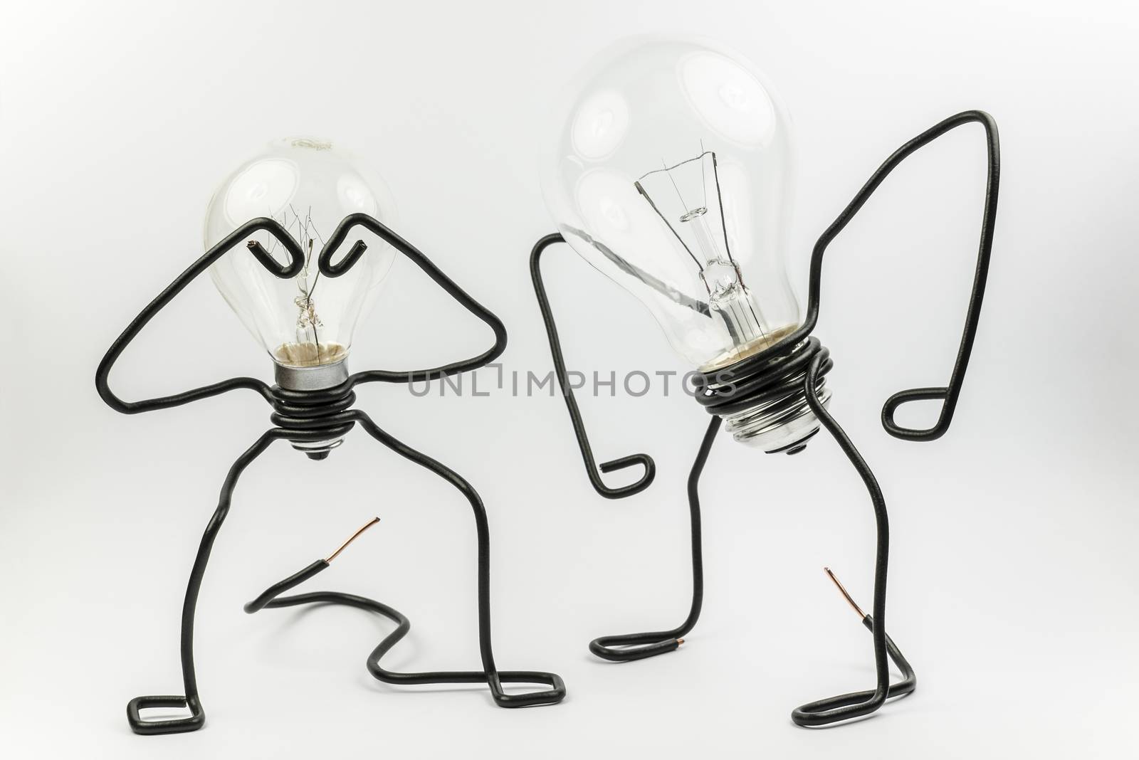 Two emotional fantasy figures of transparant light bulbs and black electrical wires
